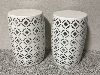 This set of 2 white round metal garden stool side tables features a patterned design, making them a decorative and functional addition to any outdoor 