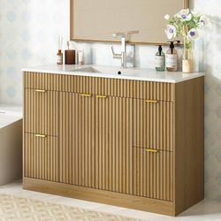 48-inch bathroom vanity (sink not included) in a natural oak finish. Modern-style vanity featuring a vertical-slat finish, complete with a sink, stora