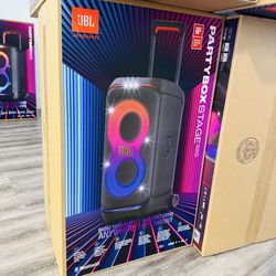 The JBL Partybox Stage 320 is a portable speaker designed for parties and outdoor events. It features a black body with colorful lighting effects on t