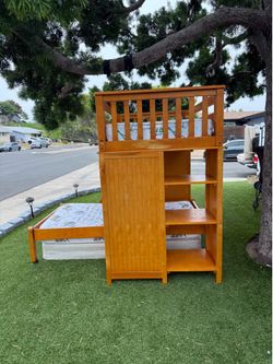 The wooden bunk bed includes both mattresses and features an office desk, five drawers, and a bookshelf.