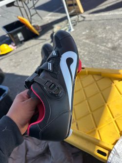 pair of Peloton Original Cycling Shoes in black with red interior lining and a ratchet buckle strap