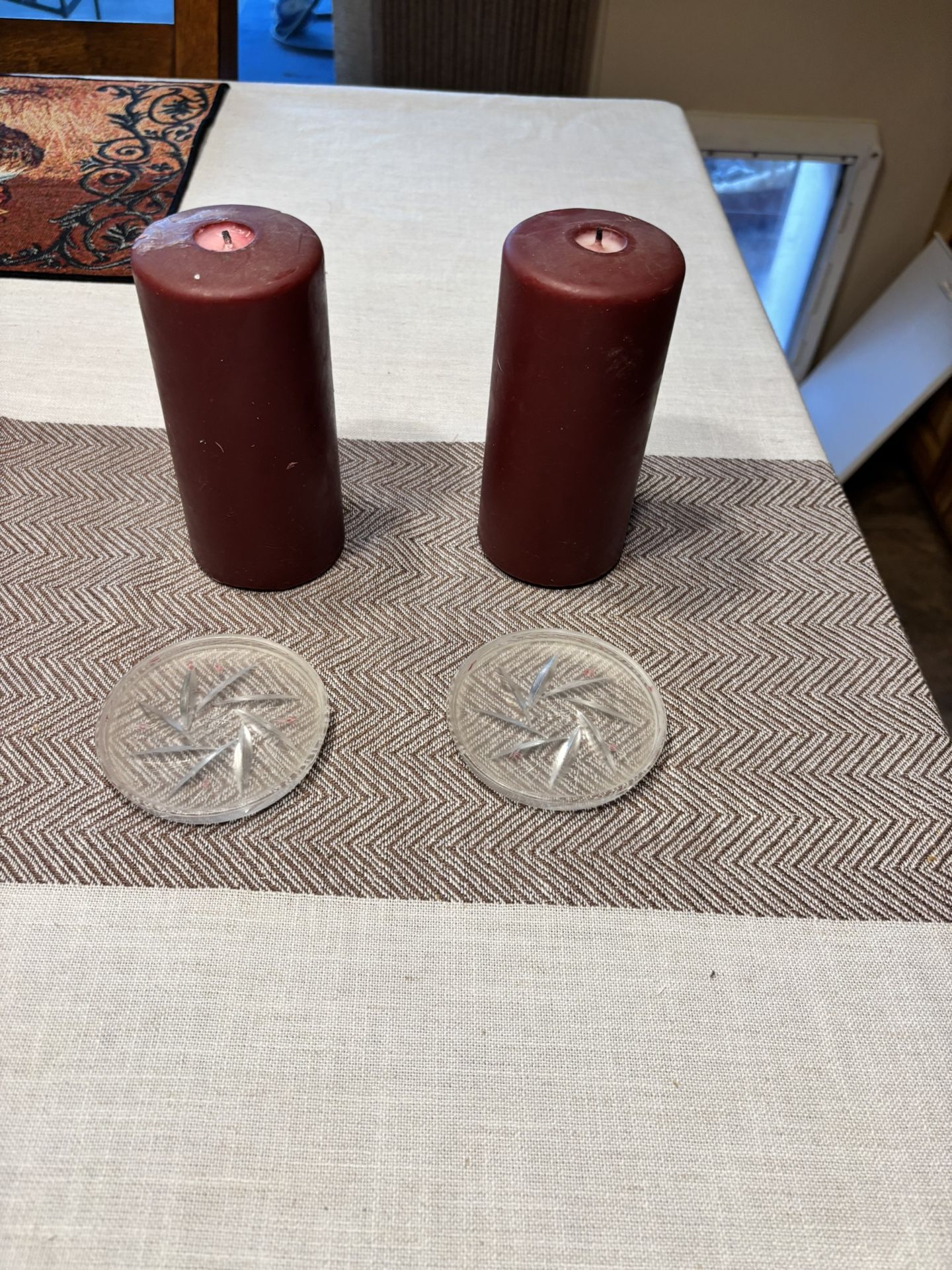 Two large candles with glass holders