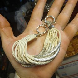 White multi-strand leather bracelet with silver-tone accents and a toggle closure. 