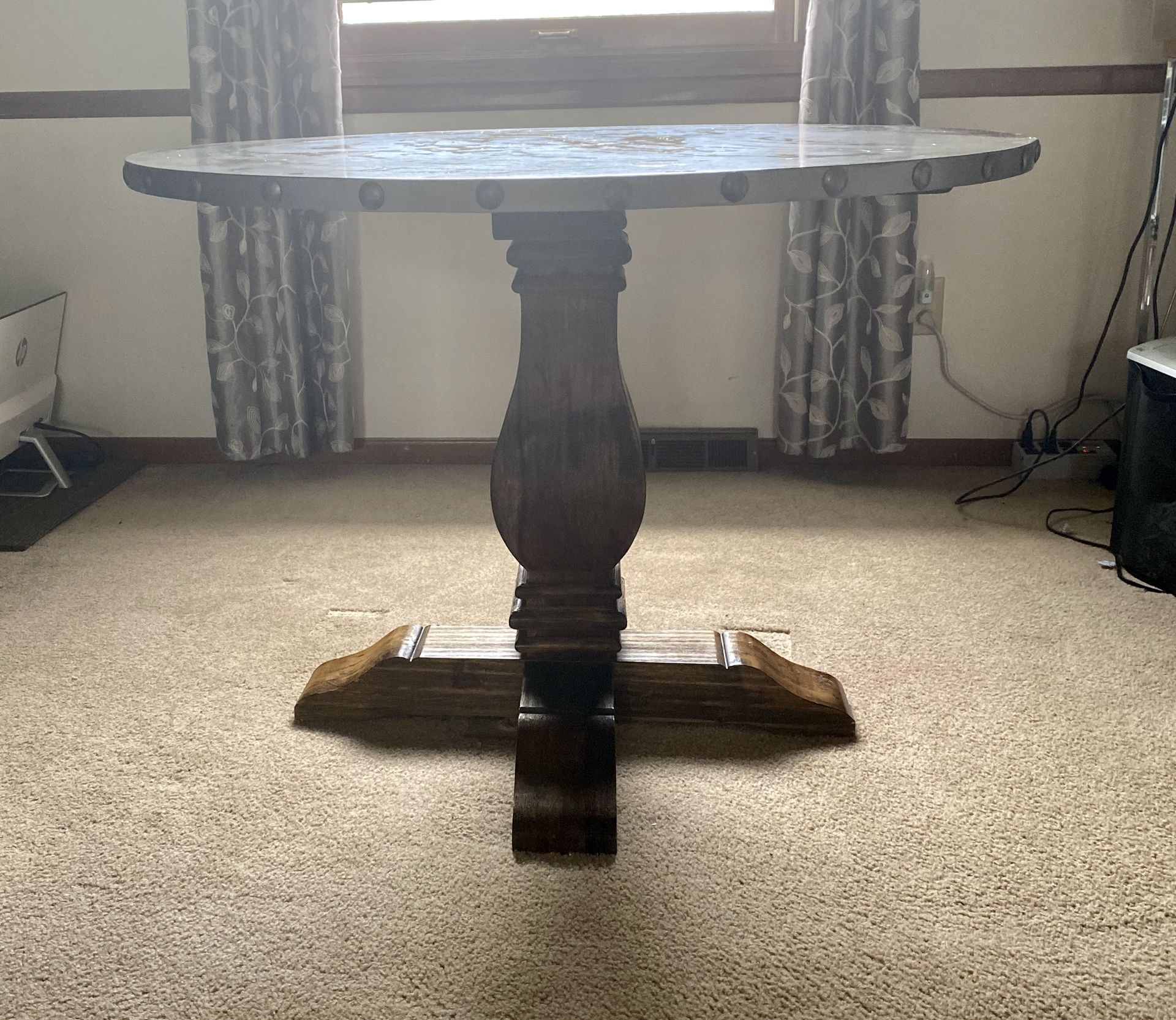 Stylish dining table with wood base. Has a few scratches on top but in good condition. Wood top with Gray laminate. Diameter=42” Height=30”