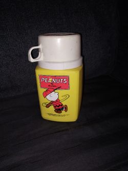 vintage Peanuts thermos, likely from the 1950s or 1960s, featuring Charlie Brown.