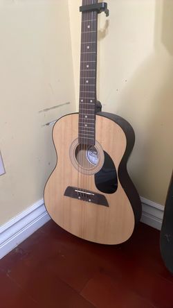 Acoustic guitar: first act, smaller body size for beginners. Hardwood fingerboard, natural spruce top.