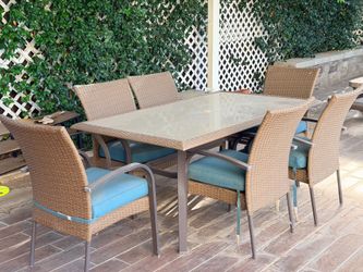 Outdoor table with glass surface and chairs.