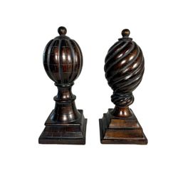 A pair of elegant decorative bronze finish finials or sculptural posts featuring classic architectural design. 