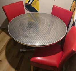 Silver table and red chairs.