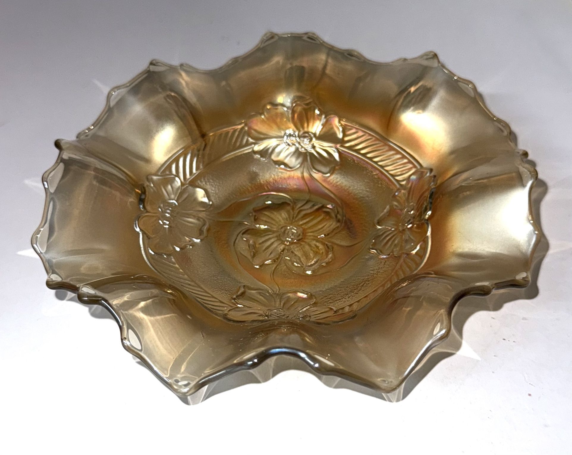 Dugan carnival glass bowl features a beautiful apple blossom pattern in marigold color with iridescent peach tones.