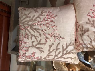 Decorative blush coral accent pillow with embroidered coral motif and bead