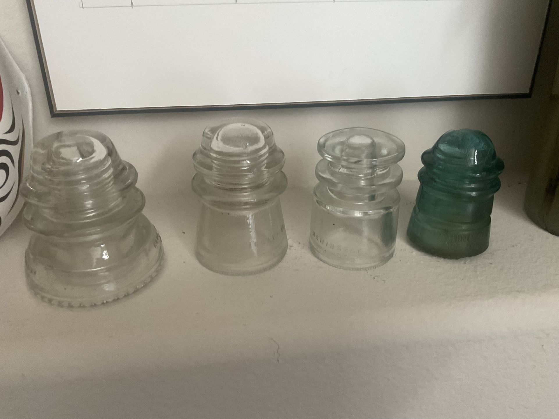 Set of 4 vintage glass insulators in clear and green.