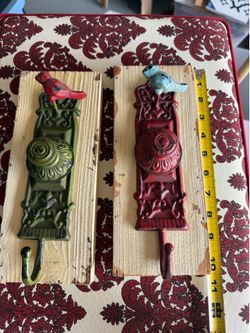 Pair of decorative rustic wall hooks feature repurposed vintage-style cast iron door backplates and knobs mounted on distressed wooden planks, topped 