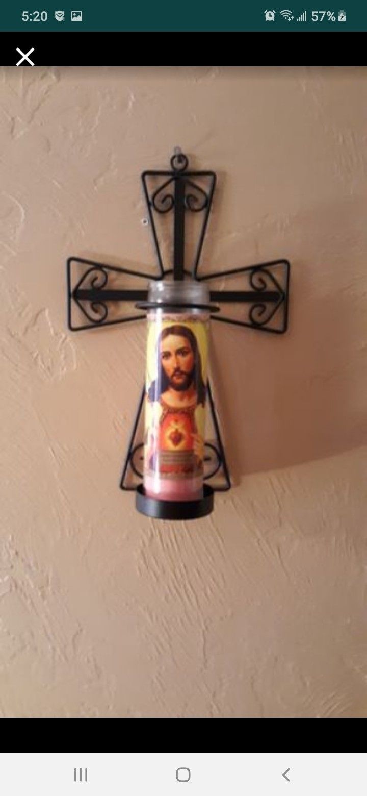 Black cross decoration for holding candles on the wall