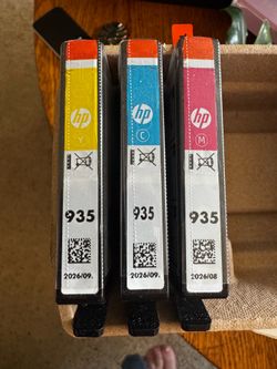 HP 935 ink cartridges in yellow, cyan, and magenta.