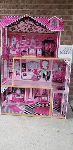 KidKraft Amelia Dollhouse featuring a vibrant pink and black design with three levels of detailed interior rooms