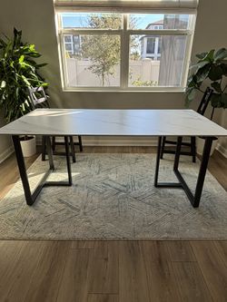 Modern table featuring a smooth polished concrete top paired with sturdy black matte metal legs. The minimalist design is durable, stylish, and perfec