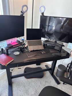 Black glass standing desk and monitors