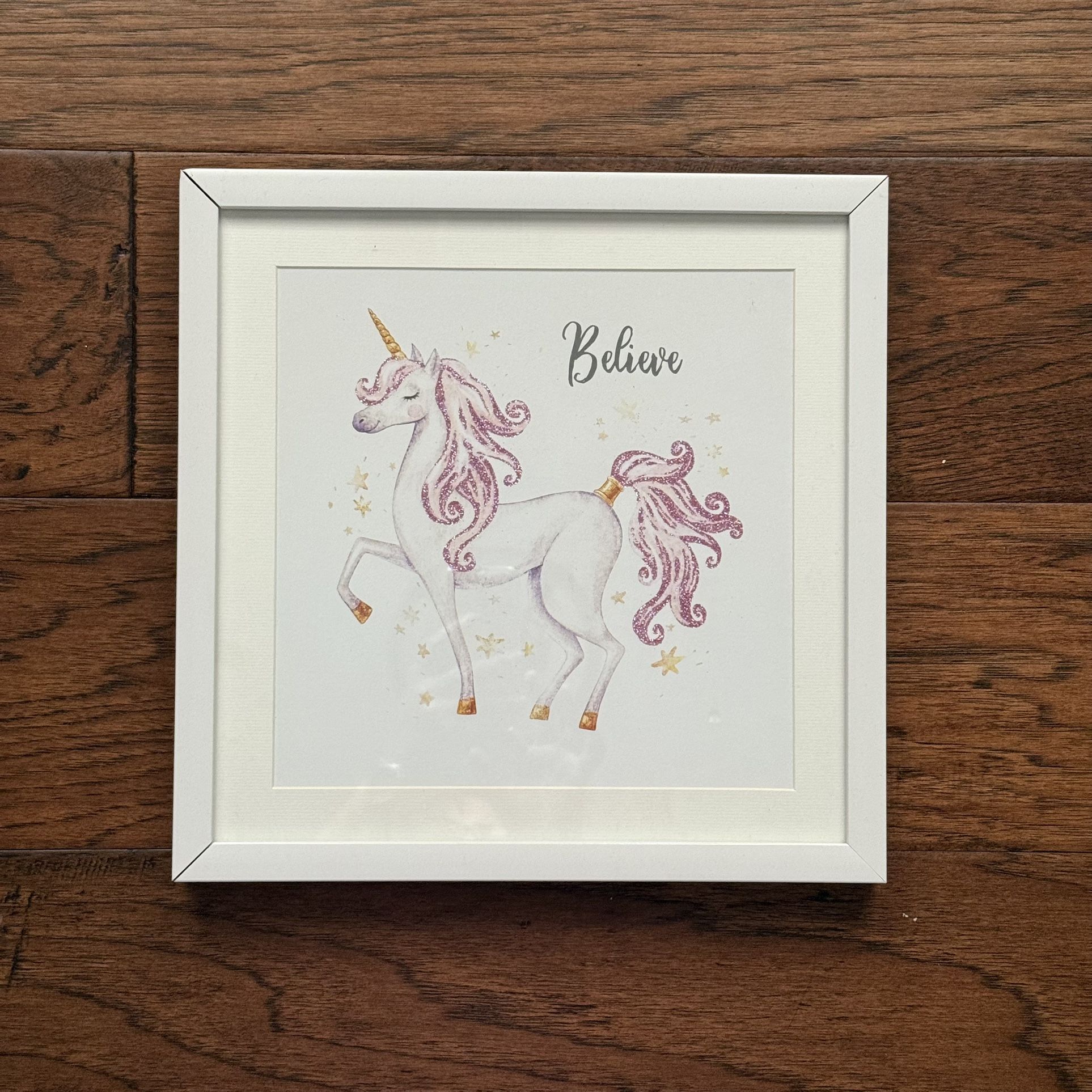 At Home Glass Framed White And Pink Unicorn “Believe” Wall Decor