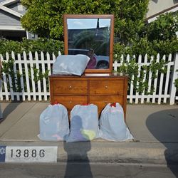 Dresser And Bags Of Clothes