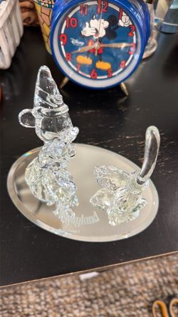 Arribas Brothers crystal figurine depicts Sorcerer Mickey from "Fantasia" and is set upon a mirrored base.