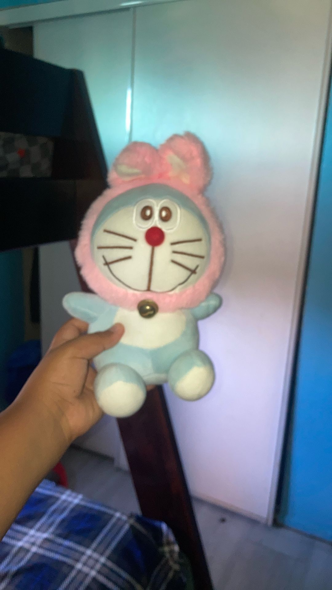 Doraemon is wearing a pink bunny costume with rabbit ears and a bell