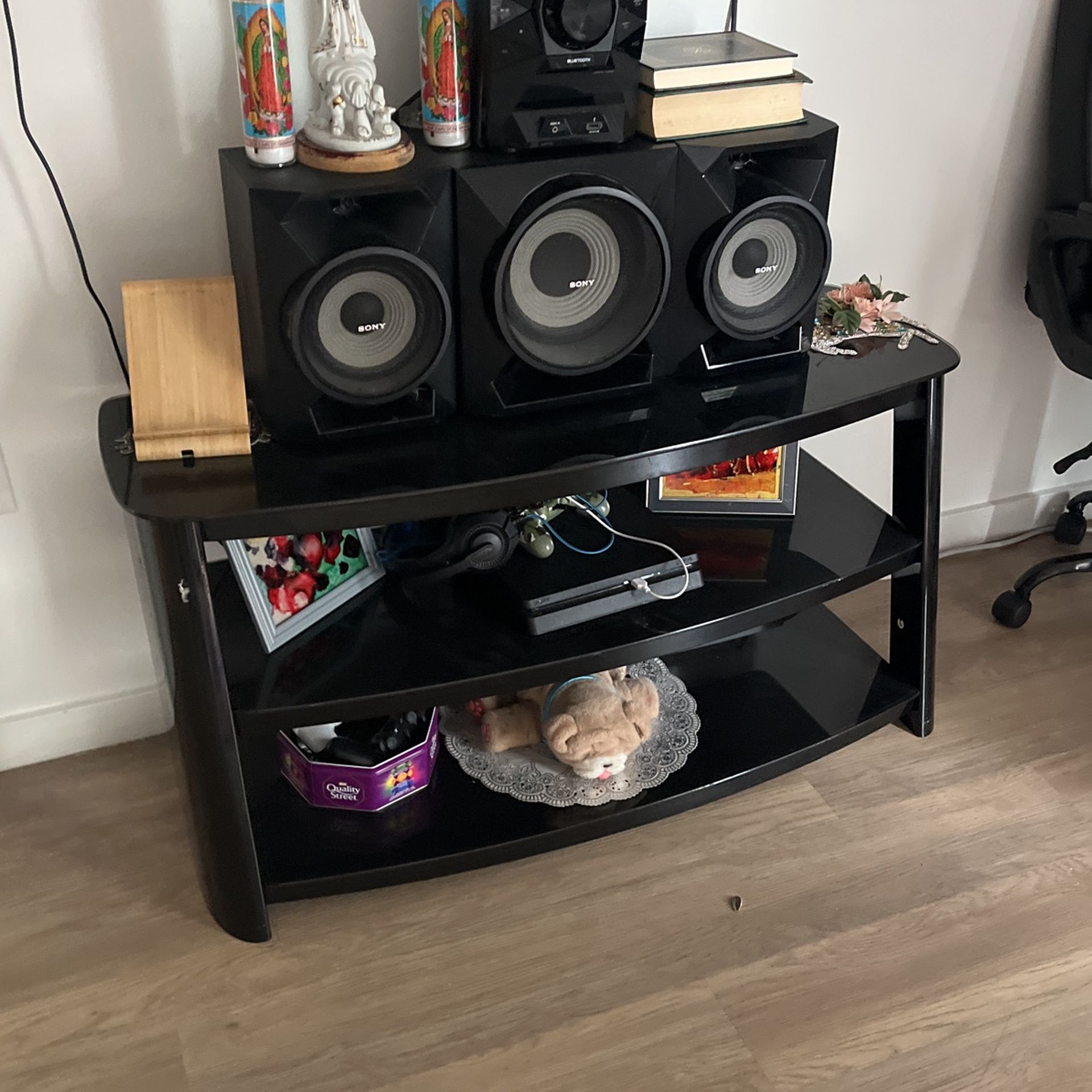 Glass table with the speaker and the TV.