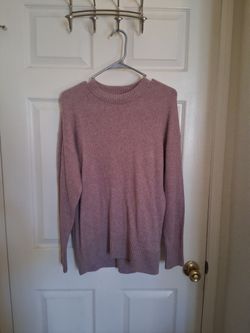 This is a cozy pink ribbed-knit crewneck sweater featuring a relaxed silhouette and drop-shoulder sleeves