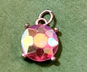 faceted chaton rhinestone set in a four-prong metal setting with a single top loop. 
