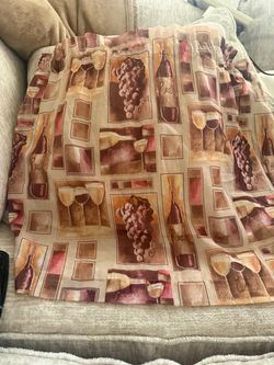 wine-themed cotton fabric featuring a square-paneled pattern of wine bottles, glasses, and clusters of grapes.