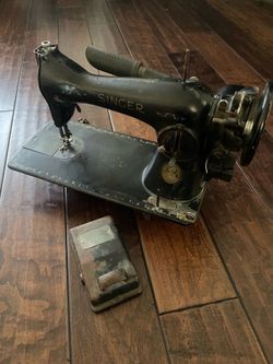 Antique vintage old black heavy Singer Singer Cast Iron Sewing Machine with foot pedal attachment.