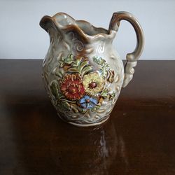 Majolica-style ceramic pitcher with hand-painted floral relief decoration