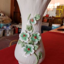 Cream colored vase with diamond pattern and raised green and white flowers and vine with crimped lip A66V729