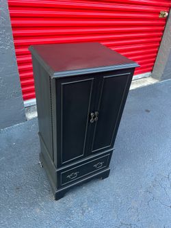 black-painted cutlery storage chest with a green velvet-lined interior.