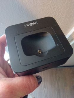 Vogek branded black charging dock designed for Bluetooth https://offerup.com/redirect/?o=aGVhZHNldHMuSXQ= features magnetic charging pins located in t