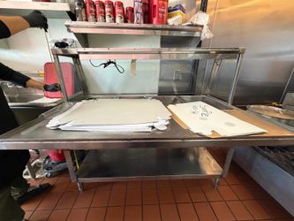 stainless steel kitchen prep table, a common fixture in commercial food service environments for food preparation or assembly