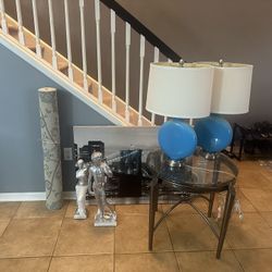 glass Crome end table, 2 teal lamps, 2 Greek Statues, City Canvas portrait and a rug 