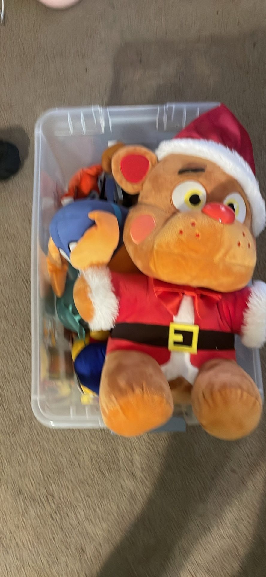 A box full of toys such as five night at Freddy’s and a Dog Man plush