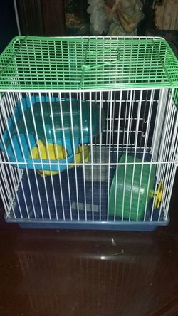 Hamster small cage with dish and toys.