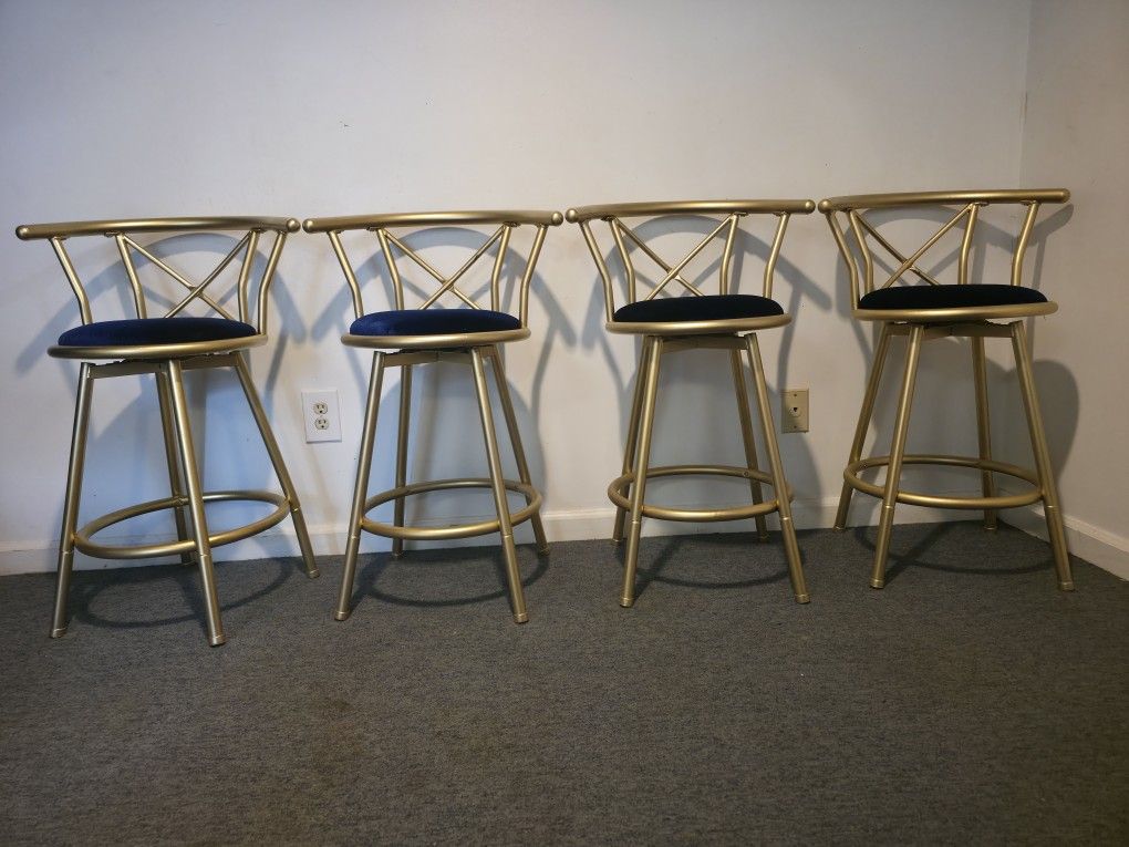 Gold metal bar stools with navy blue velvet seats.