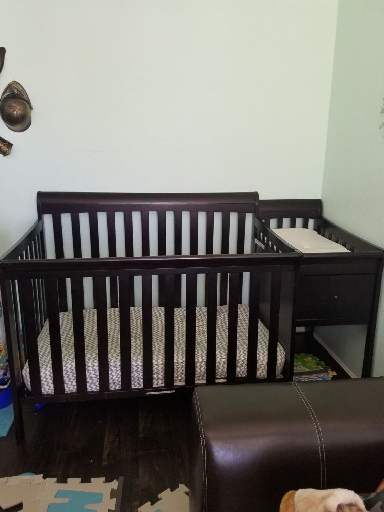 Crib and diaper changing table with connected toy storage