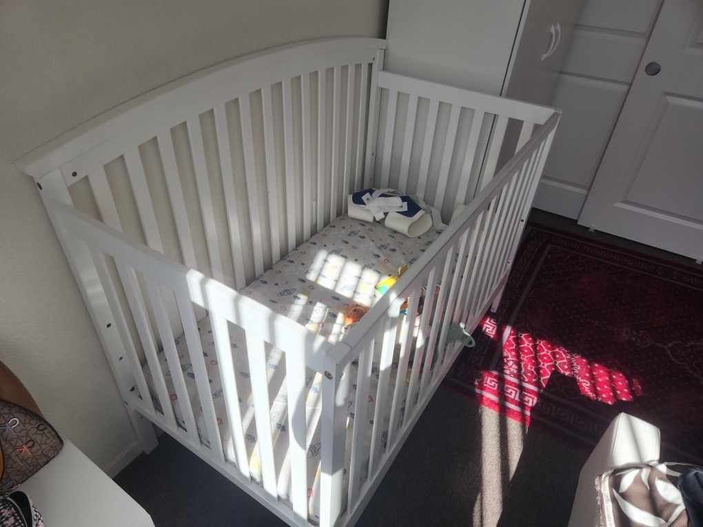 white baby crib with mattress