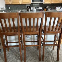 Three tall barstool chairs