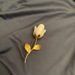 Elegant vintage brooch featuring a delicate white porcelain rosebud with five petals and bright gold-tone leaves and stem. Measures approx. 3” long. L