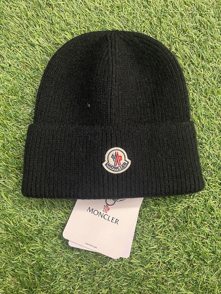 black knit cap with the Moncler logo patch on the front.