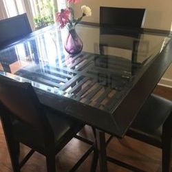 Glass top counter height dining table and four chairs in good condition