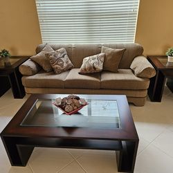 Stylish wood coffee table with glass top and shelf for storage.