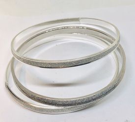 Set of silver tone bracelets with crystal dust in the middle