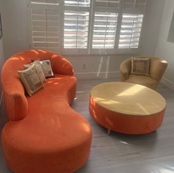 Orange couch with matching coffee table and pillows