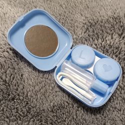 Contact lense case with rubber tipped tweezers, suction cup remover tool, and vial for solution. 